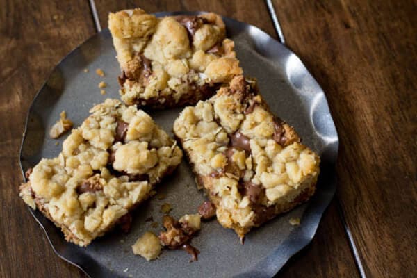 You will fall in love with these #Reeses Crumble bars. Buttery oatmeal cumble stuffed with chocolate chips and #Reesespeanutbuttercups ohsweetbasil.com_