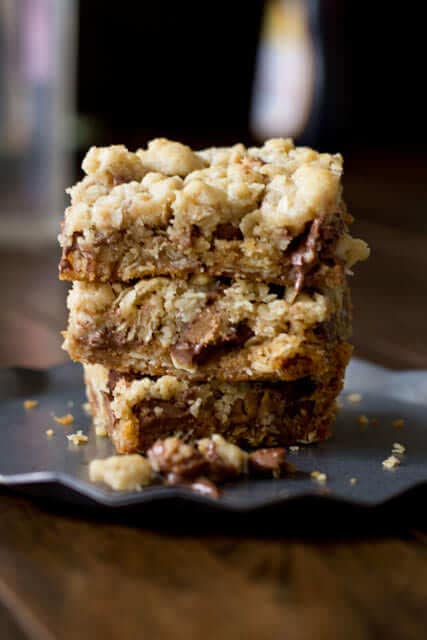 You will fall in love with these #Reeses Crumble bars. Buttery oatmeal cumble stuffed with chocolate chips and #Reesespeanutbuttercups ohsweetbasil.com_